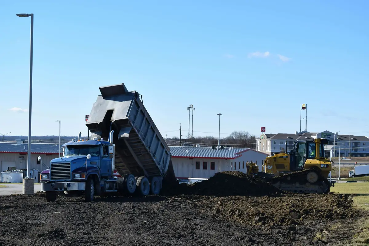 Dump truck unloading dirt on a job site